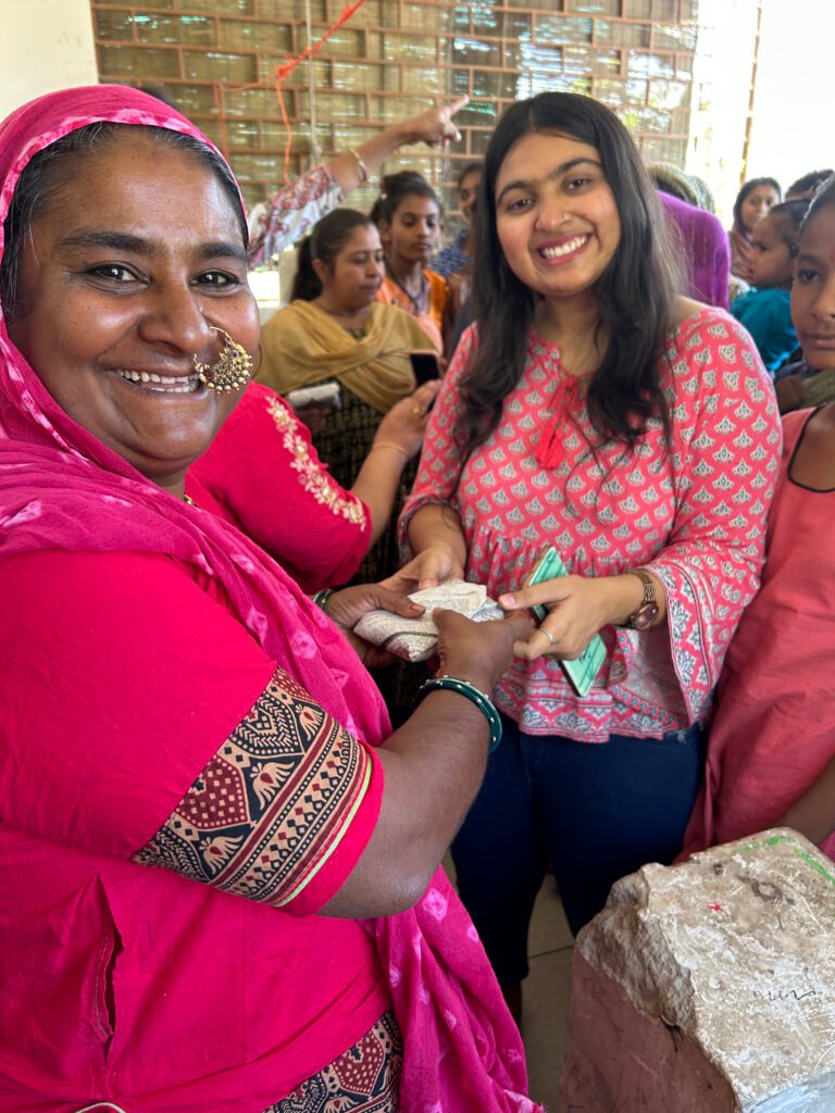 Volunteer handing a pack of sanitary pads to a woman, Ramdev Nagar, Ahmedabad